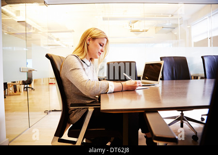 Junge Frau am Tisch arbeiten Stockfoto