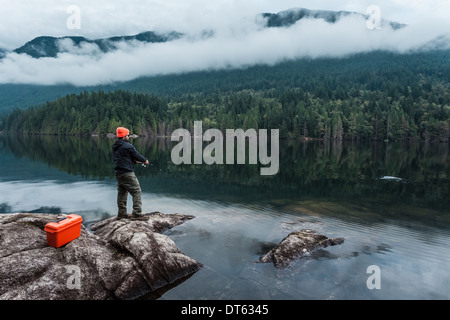 Mann Angeln vom Felsen, Buntzen Lake, British Columbia, Kanada Stockfoto