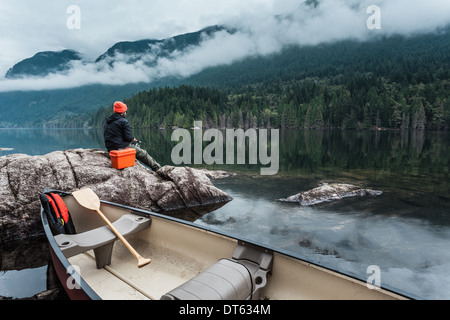 Mann Angeln vom Felsen, Buntzen Lake, British Columbia, Kanada Stockfoto