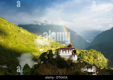 Bhutan, Südasien, Lhuentse Dzong Festung Kloster mit bunten Regenbogen über Kopf in die malerische Landschaft. Stockfoto