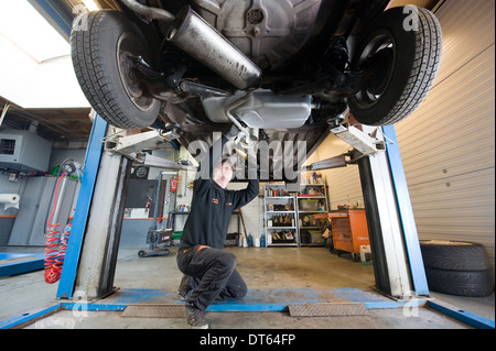 Ein Mechaniker arbeitet an einem Auto in einer garage Stockfoto