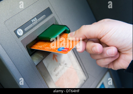 Eine Frau setzt ihre Bankkarte in ein Geldautomat Bargeld Auszahlung Stockfoto