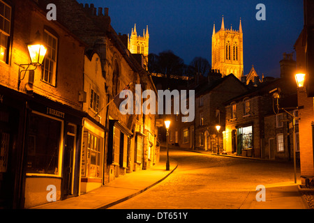 Die Ansicht der Kathedrale von Lincoln von der High Street Blick steil bergauf am Abend fotografiert. Stockfoto