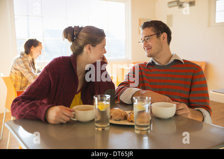 Zwei junge Menschen, ein Mann und eine junge Frau sitzt an einem Schalter in einem Café. Stockfoto