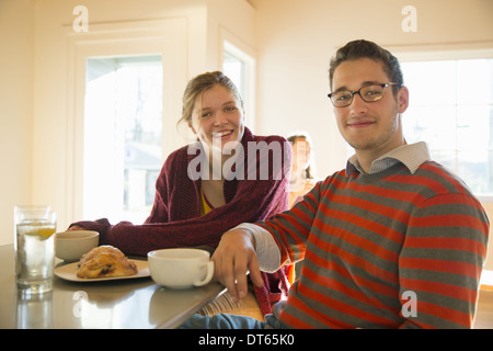 Zwei junge Menschen, ein Mann und eine junge Frau sitzt an einem Schalter in einem Café. Stockfoto