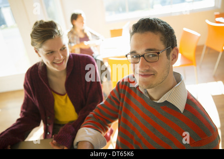 Zwei junge Menschen, ein Mann und eine junge Frau sitzt an einem Schalter in einem Café. Stockfoto