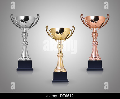 Drei Trophäen, Gold, Silber und Bronze auf grauem Hintergrund Stockfoto