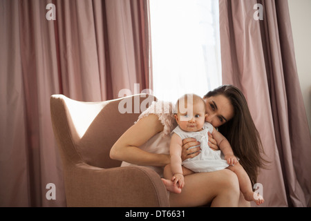 Mutter mit Baby im Sessel spielen Stockfoto