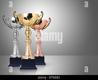 Drei Trophäen, Gold, Silber und Bronze auf grauem Hintergrund Stockfoto