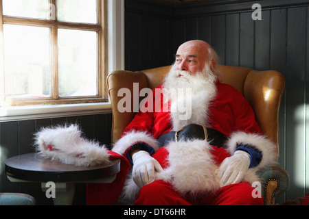 Santa Claus Einnahme Pause im Sessel Stockfoto