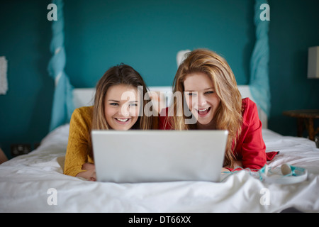 Zwei Mädchen im Teenageralter Blick auf Laptop im Schlafzimmer Stockfoto