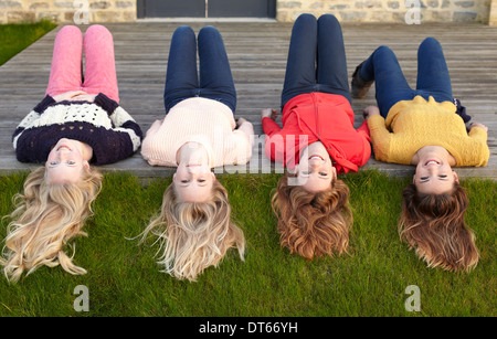 Vier Mädchen im Teenageralter liegen auf Terrasse und im Rückblick Stockfoto