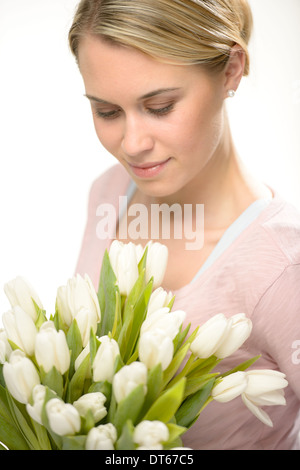 Schöne Frau auf der Suche nach weißen Blumen Frühlingsstrauß Tulpen Stockfoto