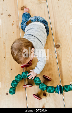 Studioaufnahme von Babymädchen spielt mit Rädern Spielzeug Stockfoto