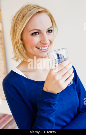 Studio-Porträt der jungen Frau mit Glas Wasser Stockfoto