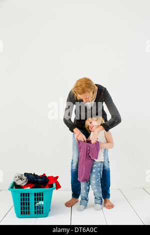 Studioaufnahme von Mutter und Tochter mit schmutziger Wäsche Stockfoto