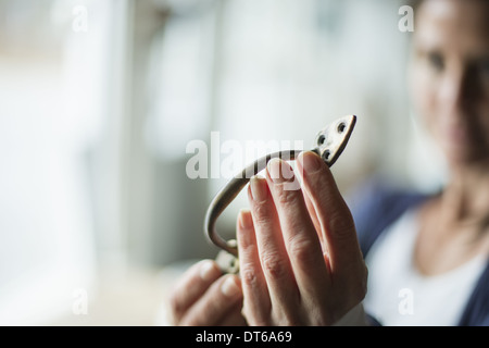 Ein Antiquitätengeschäft in einer Kleinstadt, mit Objekten und Möbeln aus der Vergangenheit. Eine Frau hält einen Türgriff oder Halterung. Stockfoto