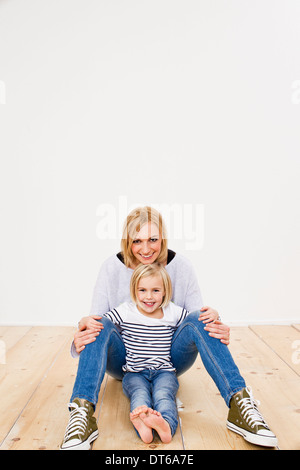 Studioportrait von Mutter und Tochter am Boden Stockfoto