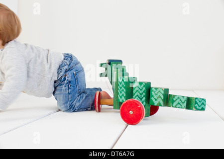 Studioaufnahme von Baby Girl und Rädern Spielzeug Stockfoto