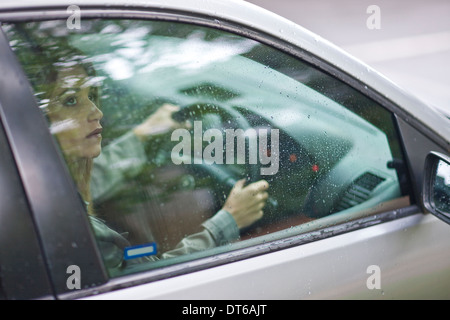 Junge Frau sitzt im Auto Blick aus Fenster Stockfoto