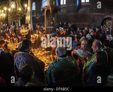 Blagoevgrad, Bulgarien. 10. Februar 2014. Am 10. Februar feiert die bulgarische orthodoxe Kirche den Tag der St. Haralambos der Märtyrer, der auch als Schutzpatron der Imker, Gärtner und Obstbauern verehrt wird. Die treuen Kerzen mit Gläser Honig während einer heiligen Messe für die '' Heiligung des Honigs '' '' Präsentation der seligen Jungfrau '' Kathedrale Kirche in der Stadt Blagoevgrad, Bulgarien. Honig ist geweiht und dann das Brot damit beschichtet ist. Der Rest des Honigs ist als Heilmittel im Haus gehalten. Bildnachweis: Hristo Vladev/NurPhoto/ZUMAPRESS.com/Alamy Live-Nachrichten Stockfoto