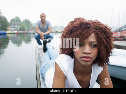 Porträt von traurig aussehende junge Frau mit Mann im Hintergrund Stockfoto