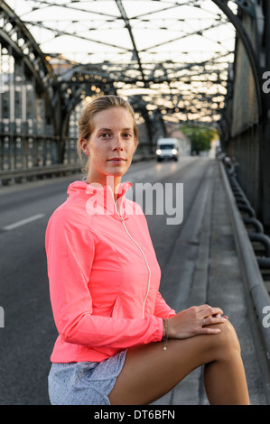 Porträt der jungen weiblichen Läufer auf Brücke Stockfoto