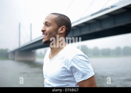 Porträt des jungen Menschen durch Brücke, Düsseldorf, Deutschland Stockfoto