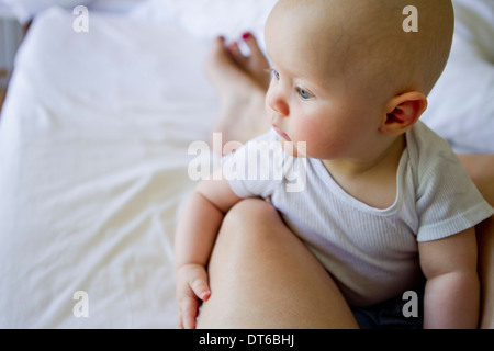 Babymädchen auf Mutters Schoß Stockfoto