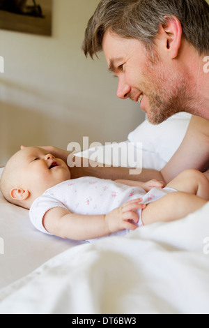 Vater und Baby Tochter auf Bett Stockfoto