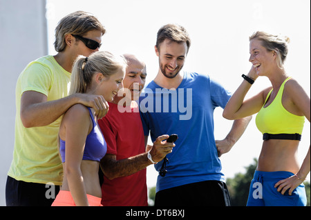 Ältere männliche Trainer und eine Gruppe von Erwachsenen Läufer Check-Stoppuhr Stockfoto