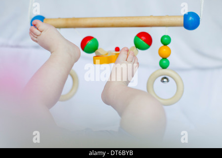 Baby Mädchen die Füße spielen mit Handy Stockfoto