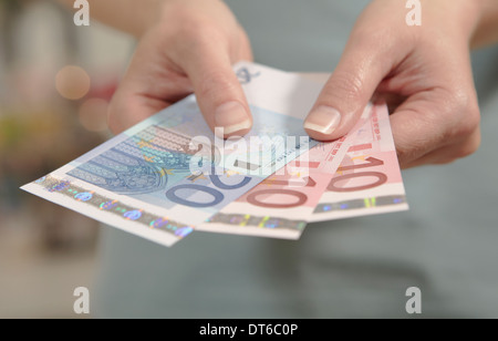 Weibliche Hände halten zehn und zwanzig Euro-Banknoten Stockfoto