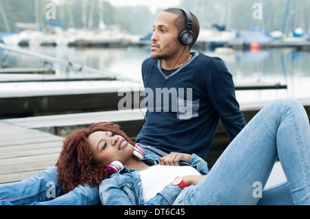 Junges Paar sitzt am Steg Stockfoto