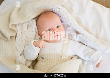 Babymädchen liegen auf Bettwäsche Stockfoto