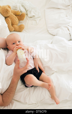 Vater mit der Flasche füttern Baby Tochter Stockfoto