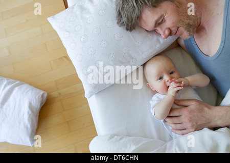 Vater und Baby Tochter auf Bett Stockfoto