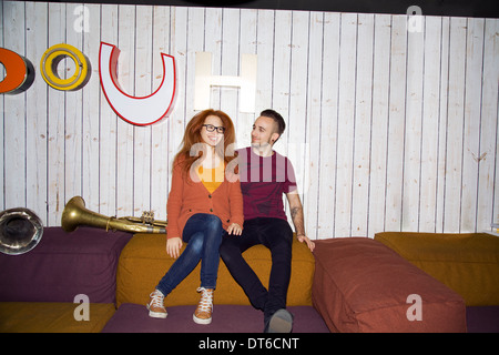 Porträt von funky junges Paar sitzt auf Sitze im club Stockfoto