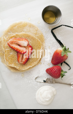 Eine Auswahl an Party-Desserts. Pfannkuchen, frisch gekocht, mit Erdbeeren und ein Getränk. Bio-Lebensmittel. Stockfoto