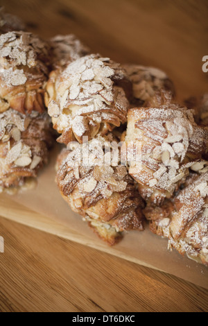 Eine Gruppe von frisch gebackene Mandel Croissants mit Puderzucker Zucker bestäuben. Bio-Party Essen Nachtisch. Stockfoto