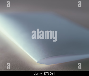 Ein gefaltetes Stück weißes Recyclingpapier hautnah. Stockfoto