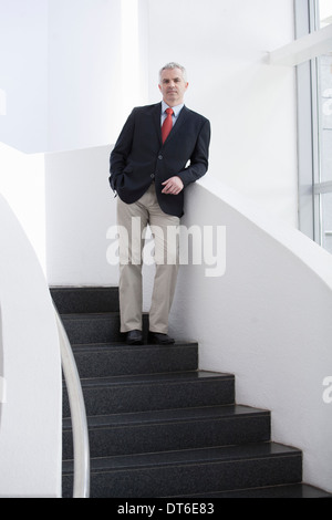 Porträt von reifer Geschäftsmann auf Büro-Treppe Stockfoto