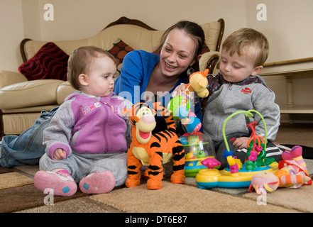 Eine junge Mutter mit ihren beiden Kindern zu Hause spielen. Stockfoto