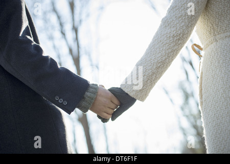 Zwei Personen, ein paar, Mann und Frau im Wald an einem Wintertag. Halten die Hände. Stockfoto