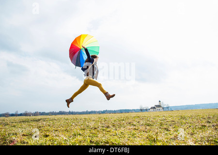 Teenager-Mädchen im Feld mit Regenschirm Stockfoto