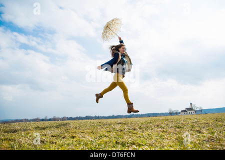 Teenager-Mädchen im Feld mit Regenschirm Stockfoto