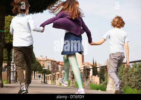 Jungen und älteren Schwester marschieren durch den Park, Provinz Venedig, Italien Stockfoto