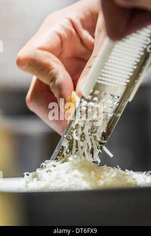 Nahaufnahme eines männlichen Hand reiben von Parmesan-Käse Stockfoto