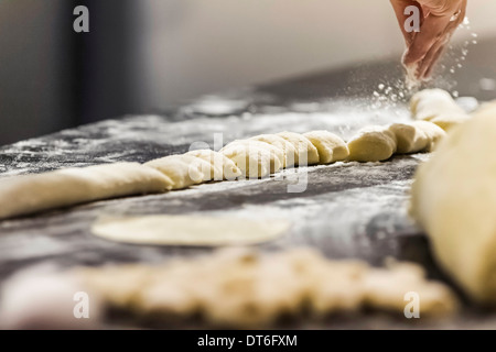 Kochs Hand man Mehl auf Gnocchi in Großküchen Stockfoto