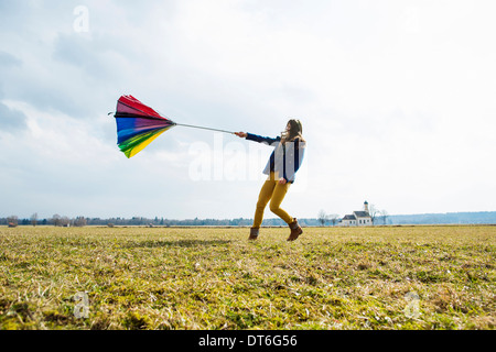 Teenager-Mädchen im Feld mit Regenschirm Stockfoto